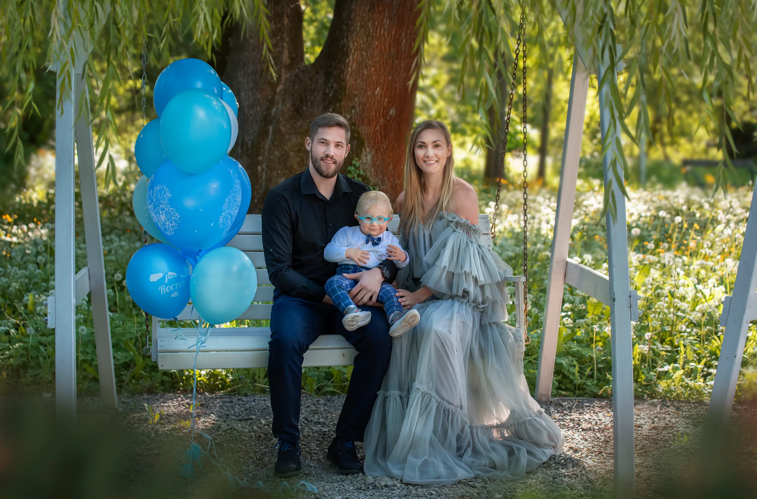 fotografia-rodzinna-rodzice-z-dzieckiem-siedzacy-na-lawce-w-parku-w-Cieszynie