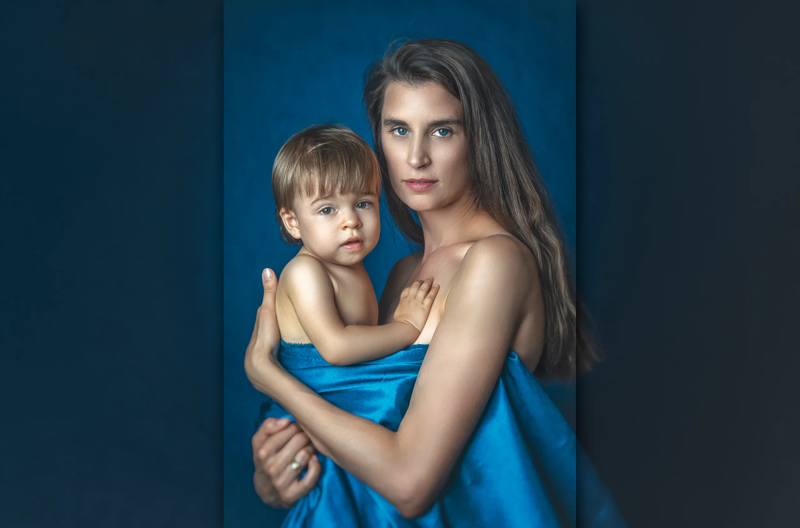mama-z-dzieckiem-na-rekach-zdjecie-artystyczne-wykonane-w-studiu-fotograficznym-na-niebieskim-tle-malarskim