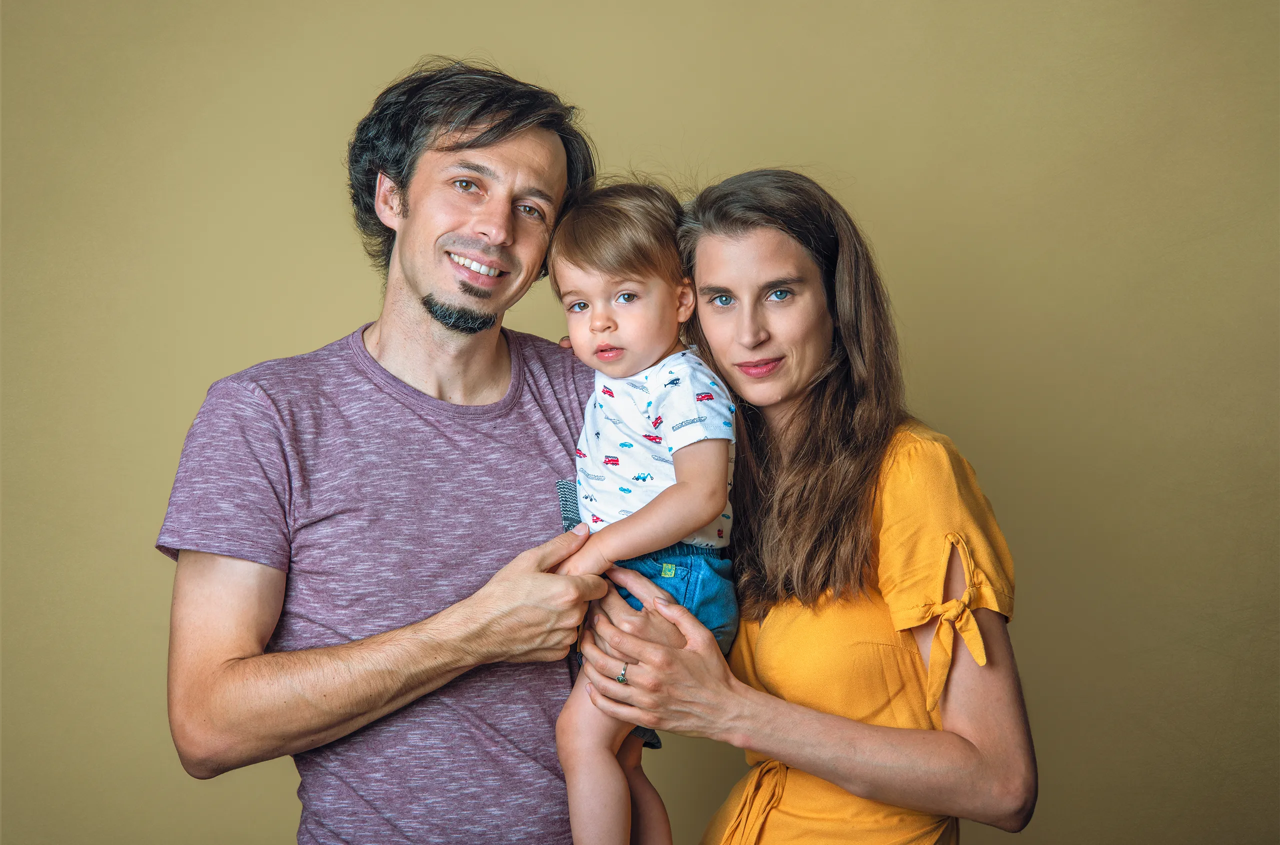 sesja-zdjeciowa-rodzinna-rodzice-trzymajacy-dziecko-w-studiu-na-slasku
